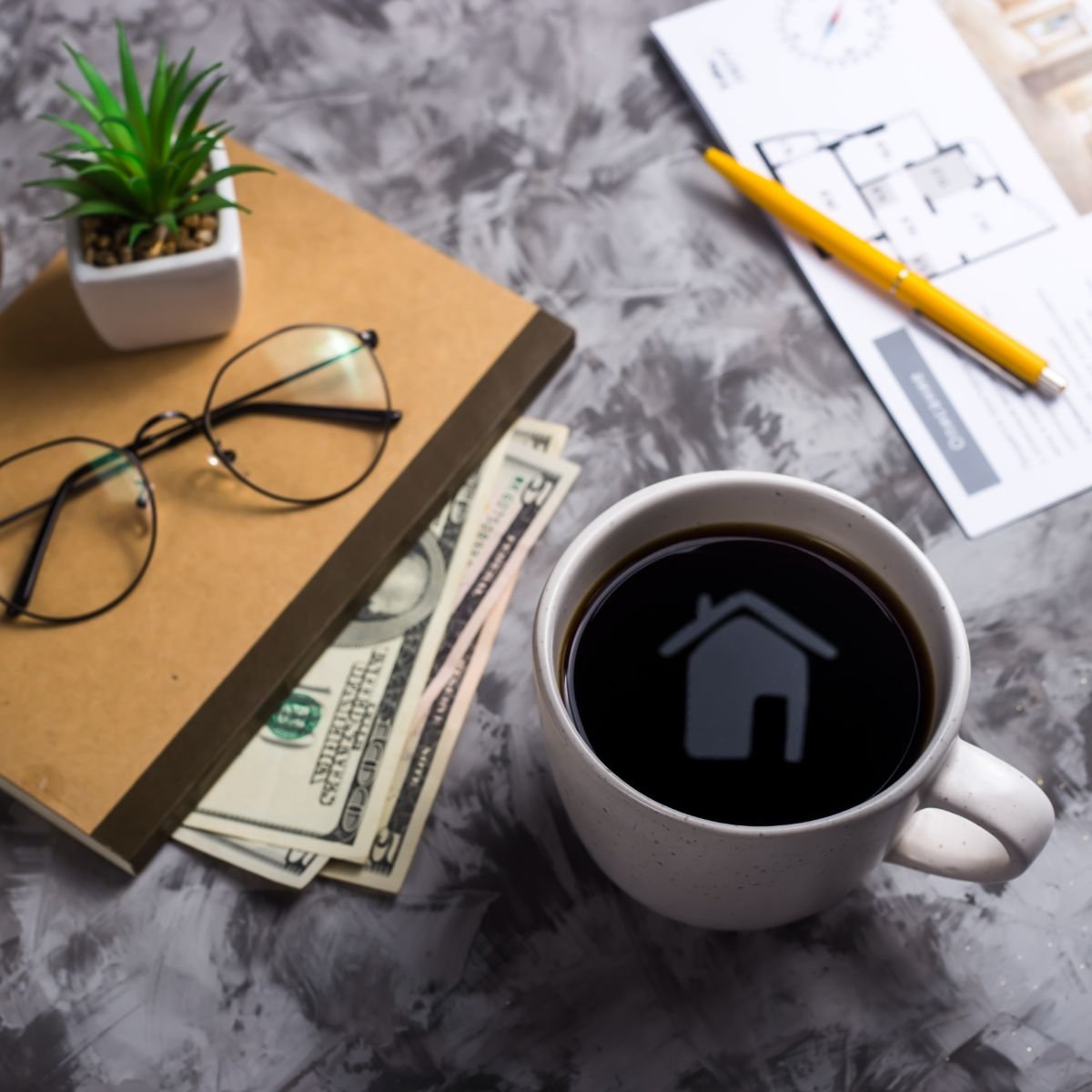 high-angle-view-coffee-cup-by-paper-currency-book-table (1)